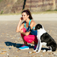 Fitness Woman And Dog On Beach